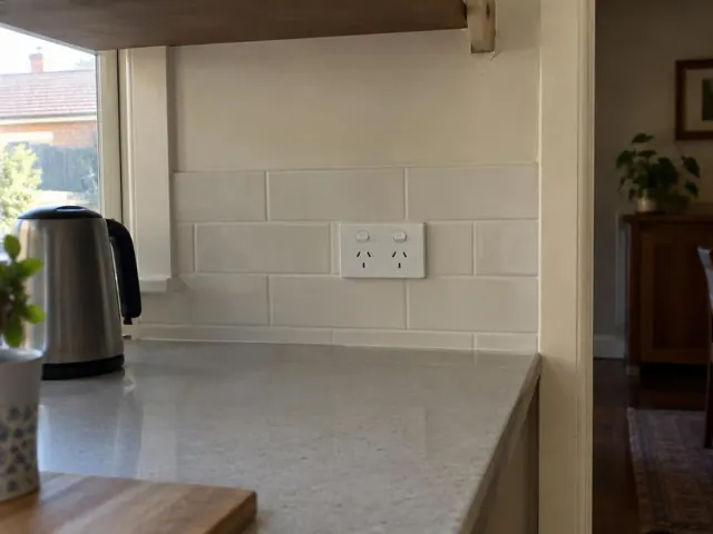 White double power point on a tiled kitchen splashback above a grey benchtop in Waratah