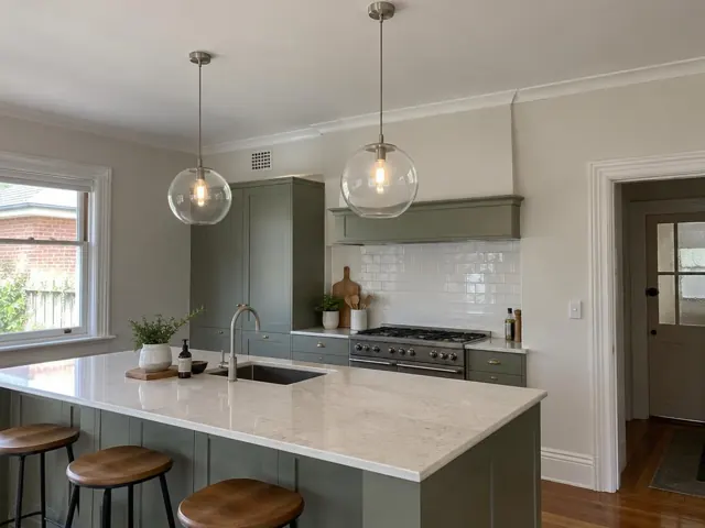 Two glass pendant lights over a kitchen island in a modern home interior in North Lambton